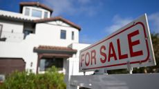 A home with a for sale sign in front of it