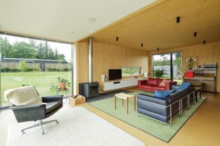 wood clad living room with picture window and stove