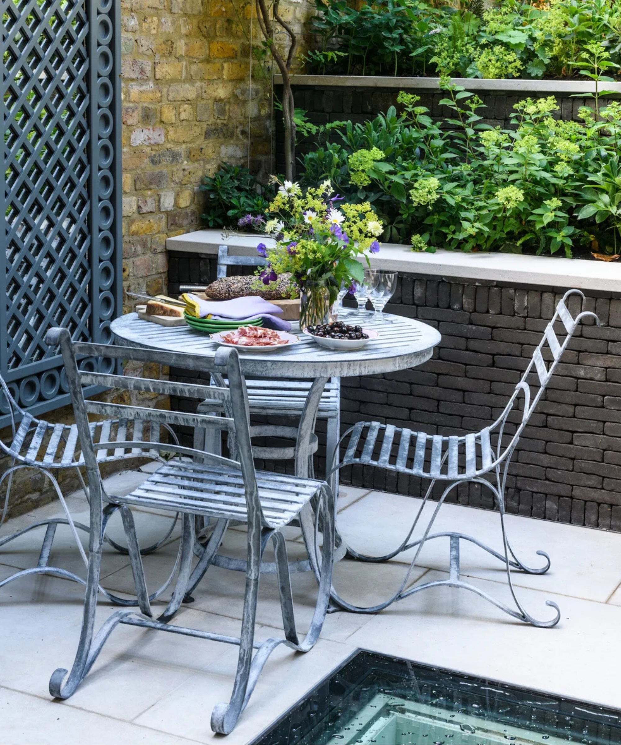 vintage style metal garden furniture in English courtyard garden
