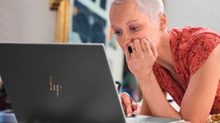 A woman looks at the screen of an HP Envy 16.