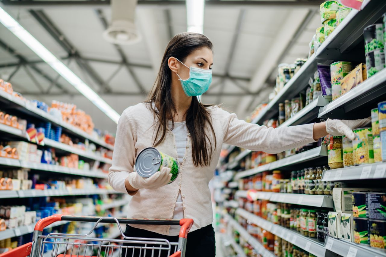 A woman with a mask shops in a grocery store.