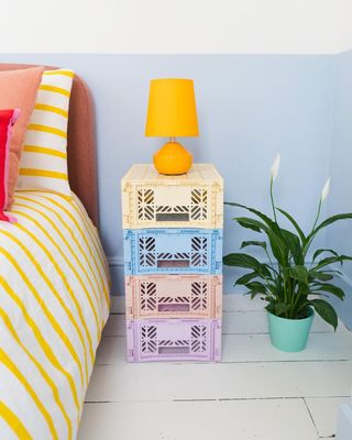 Pastel crates stacked next to a bed