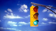 Green traffic light against a blue sky with clouds