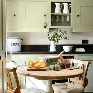 kitchen room with black worktop and cabinets with wooden table and chairs