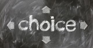 The word "choice" written on a chalkboard surrounded by letters.
