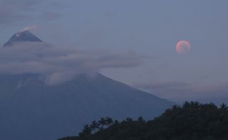 The total lunar eclipse of June 15, 2011 turns the moon a blood-red hue as steam rises from the Mayon volcano on Cagraray Island, Albay in the Philippines. Skywatcher David Matthews snapped this photo just before moonset during the eclipse.