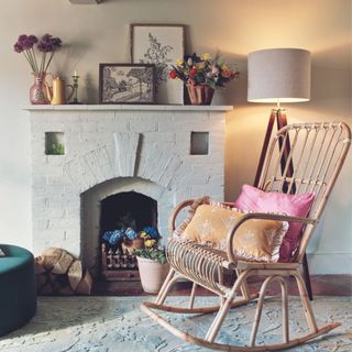 laura ashely rocking chair next to a fireplace in white walled snug