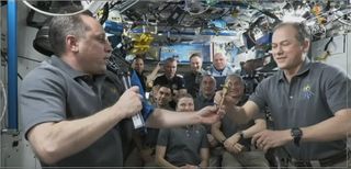 Anton Shkaplerov (left) hands over command of the International Space Station to NASA astronaut Thomas Marshburn (right) on March 29, 2022.