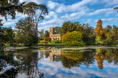 The parish church of St Mary’s, with Catalpa bignonioides ‘Aurea’ reflected in the lake on the right. Thenford Arboretum, photographed by Clive Nichols.