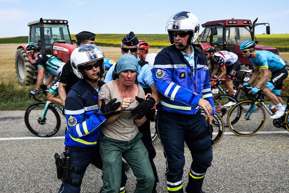 A protester is pushed off the road