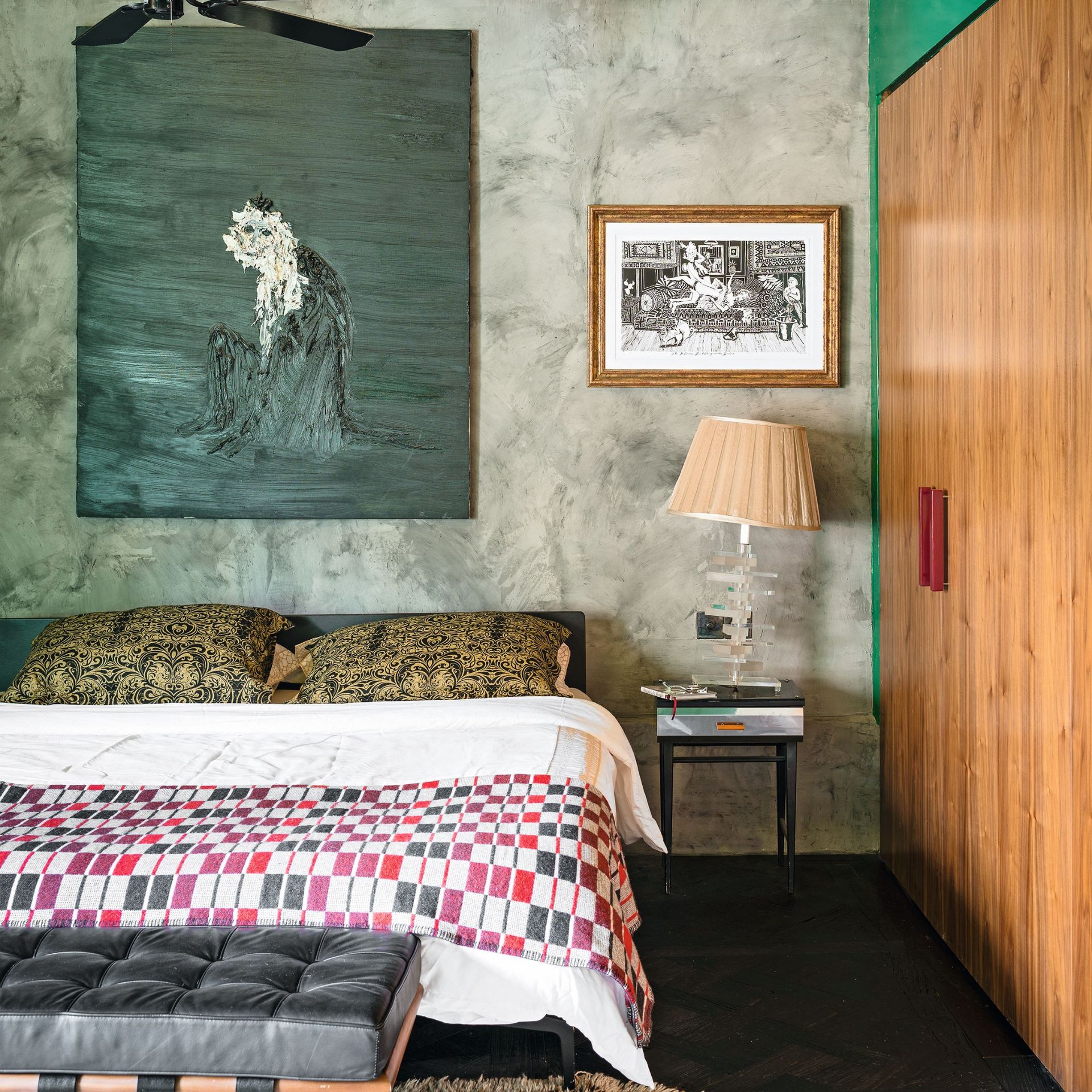 Master bedroom with antique ash floor, gold foil ceiling, raw concrete wall, double bed and Barcelona black leather bench