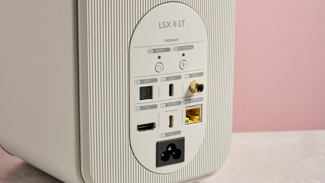The KEF LSX II LT speaker against a pink background showing the connections