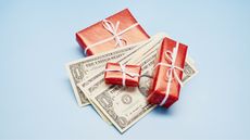 Three small gifts wrapped in red with white bows and cash interspersed.