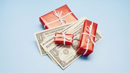 Three small gifts wrapped in red with white bows and cash interspersed.