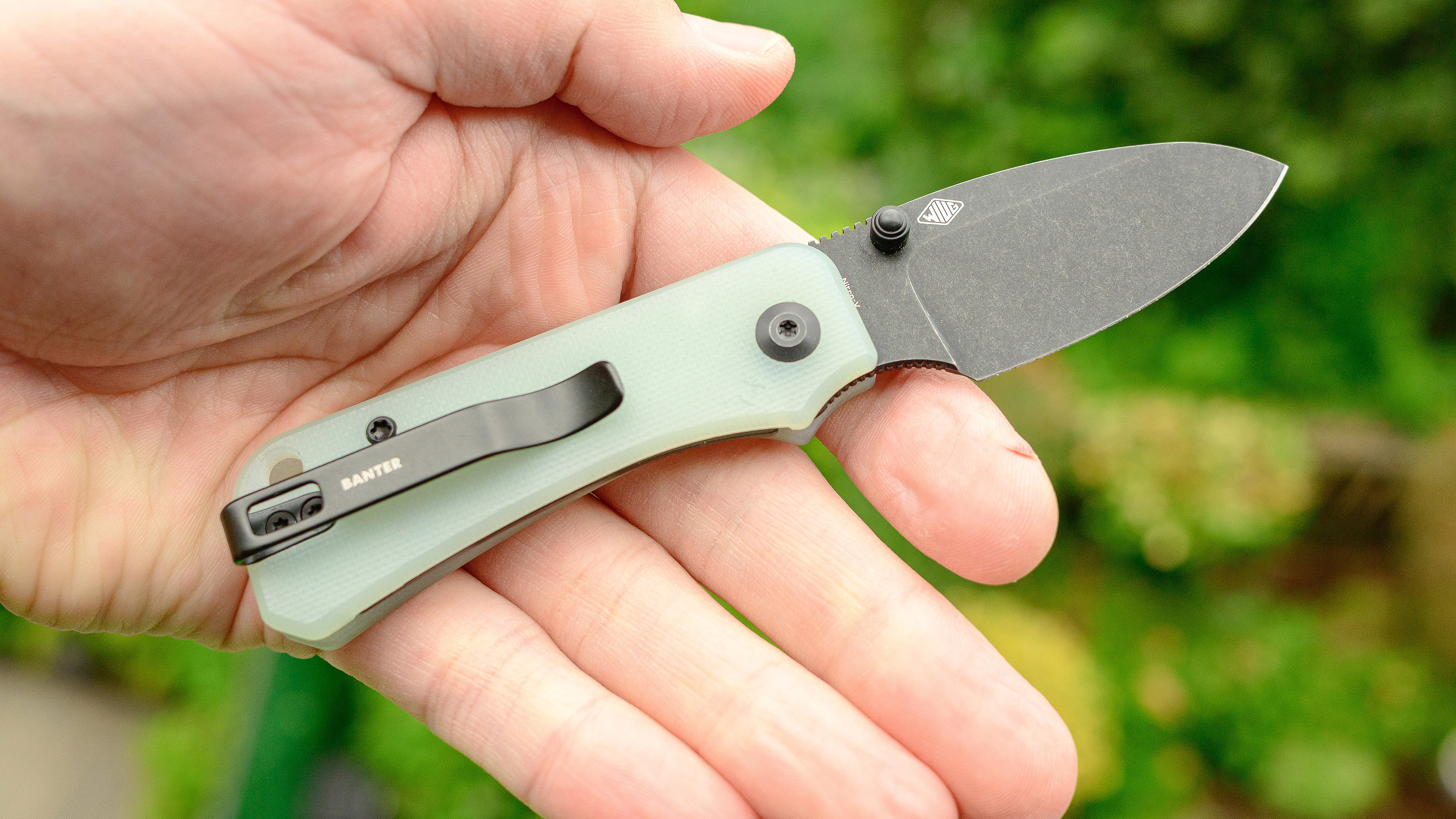 The Civivi Baby Banter folding pocket knife in a user's hand with a light green handle.