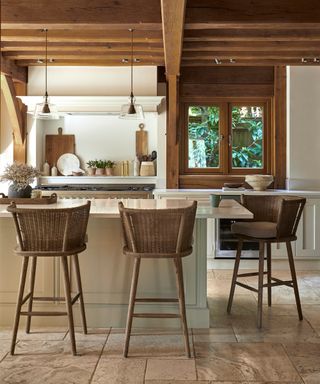 kitchen with oak beamed ceiling, kitchen island in cream with barstools