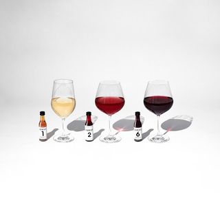 jukes non-alcoholic drink mixers in three wine glasses against white background