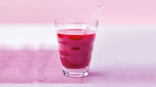 Beetroot-based healthy smoothie recipe in a glass with a straw