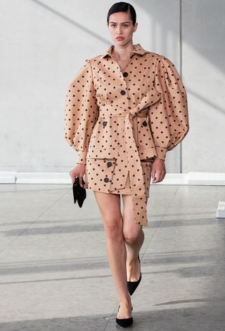 a photo of a model wearing a polka dot puff sleeve jacket with a matching mini skirt at Carolina Herrera's spring 2024 runway show
