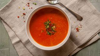 Tomato soup in a bowl with a spoon