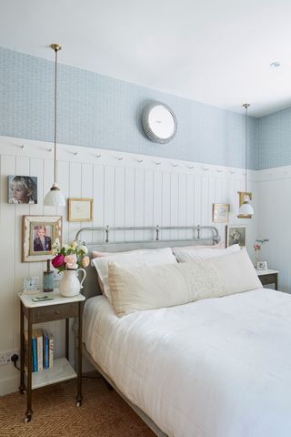 metal bedframe in bedroom with white bedlinen and panelled walls