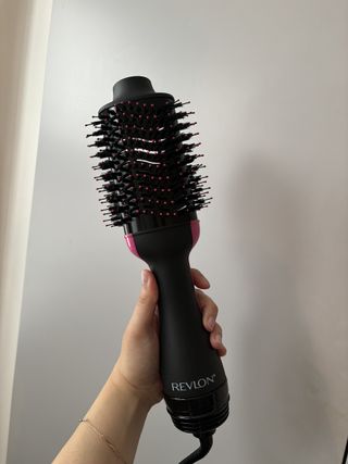 Mica sosteniendo el secador y voluminizador de cabello Revlon One Step