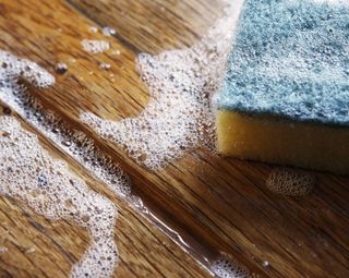 how to clean outdoor wooden furniture: soapy sponge