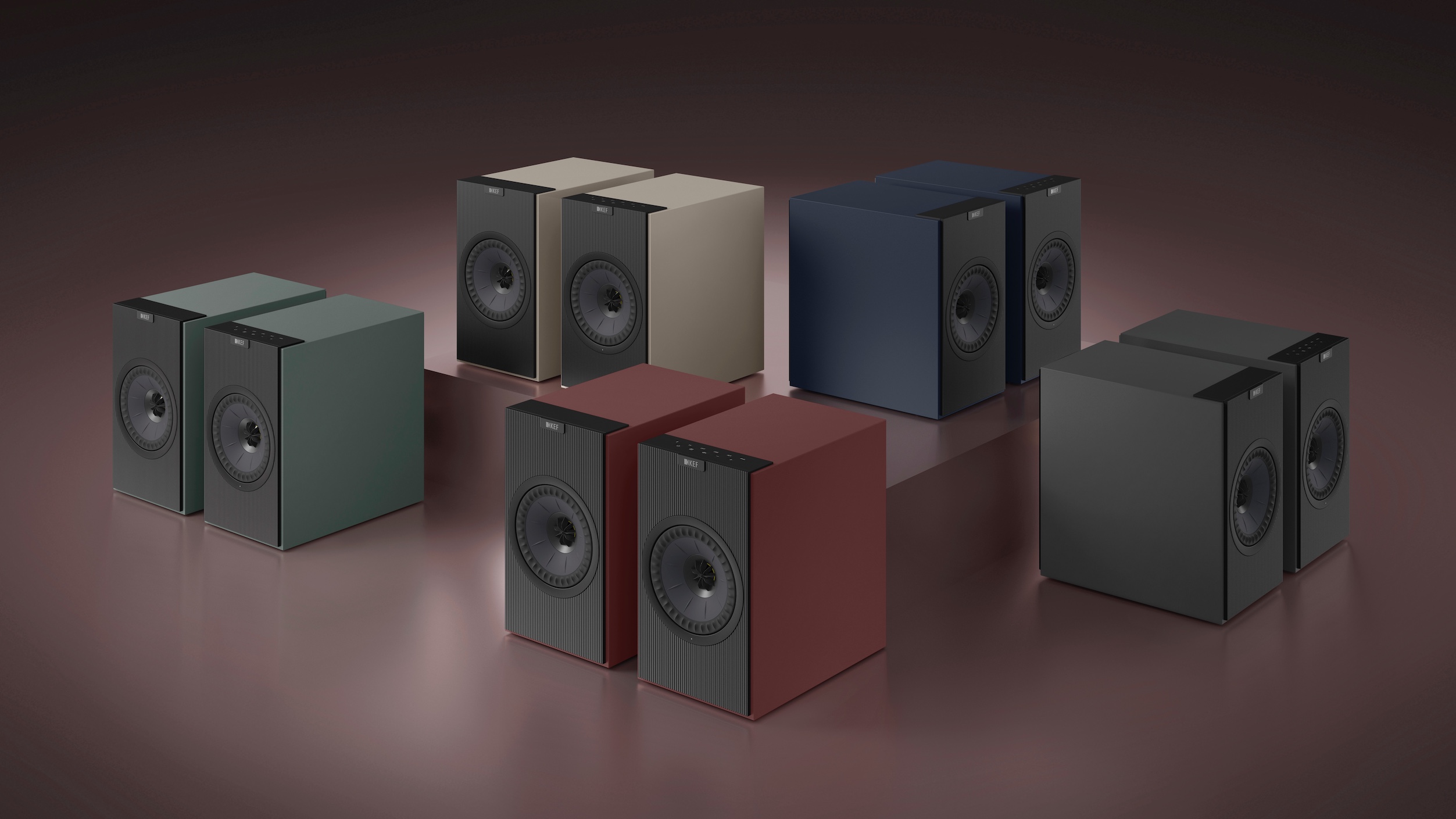 Five pairs of the KEF Coda W speaker arranged on a burgundy red background.