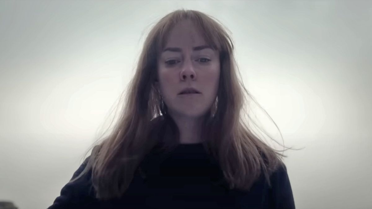 Jena Malone looks down at something off-camera in Consecration