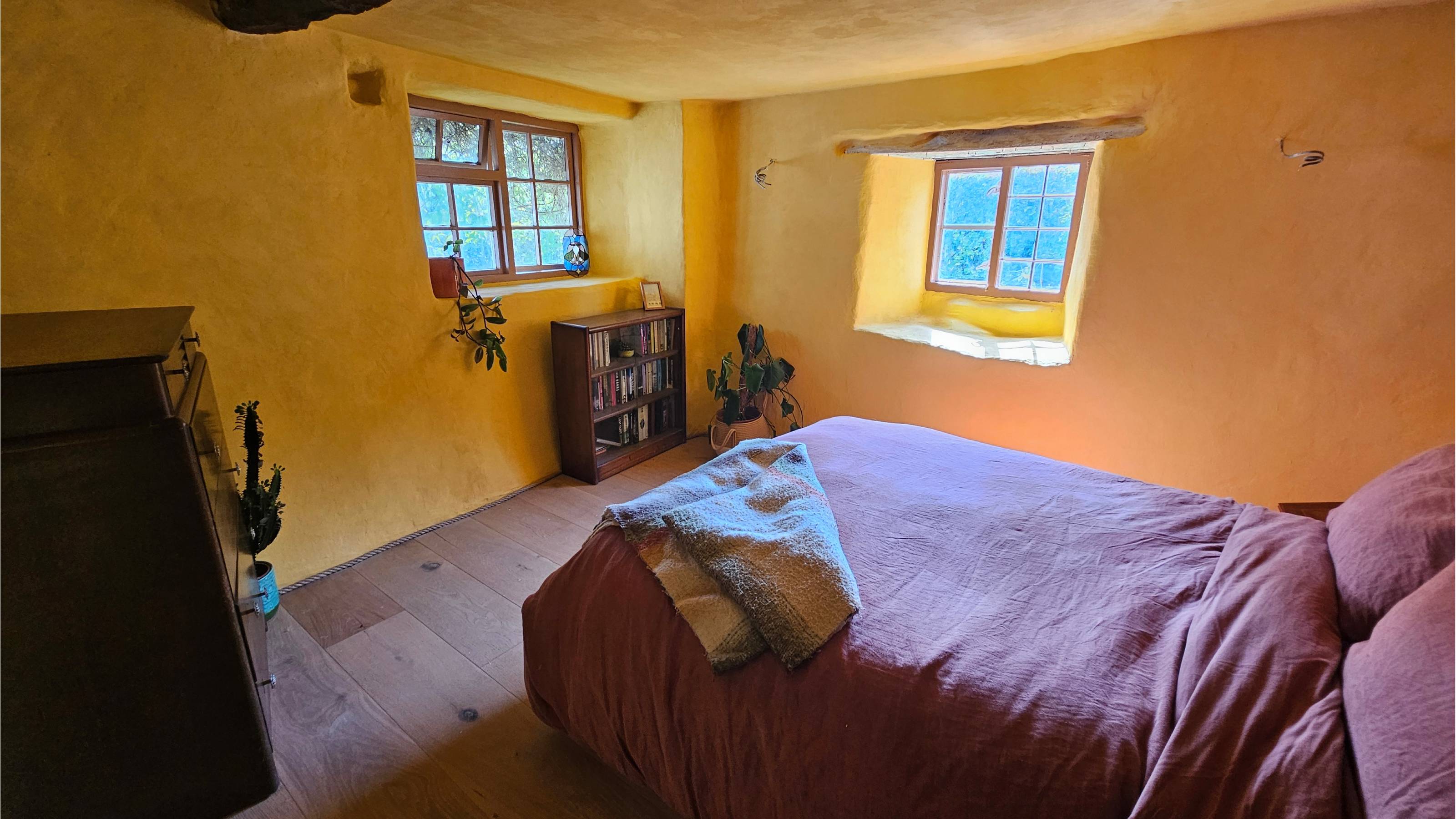 yellow bedroom with wooden floor and red bedding