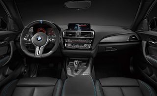 The black interior, steering wheel and dashboard of the BMW M2 .
