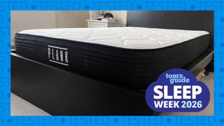 The Plank Firm mattress on a bed frame in our reviewer's bedroom. A blue border with the word 'tested' runs around the edge while a Tom's Guide Sleep Week graphic sits in the bottom right corner