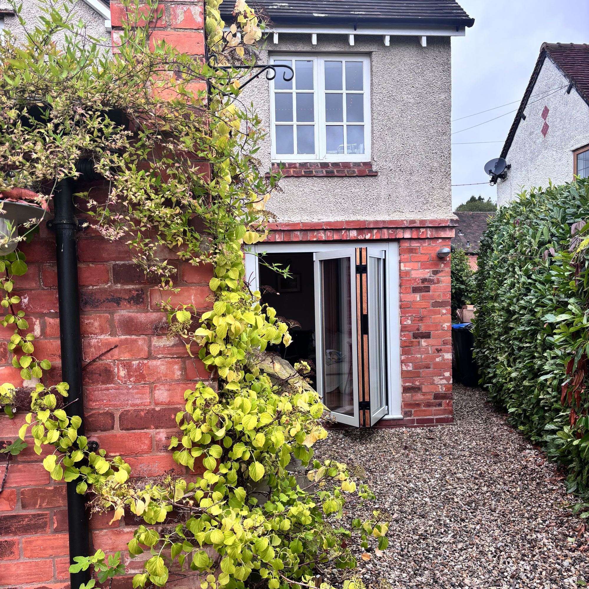 grey aluminium bi-fold doors leading out to gravelled area