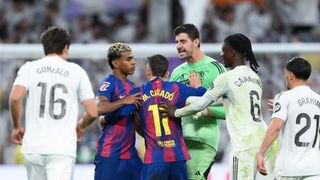 MADRID, SPAIN - OCTOBER 26: Lamine Yamal of FC Barcelona is held back by Marc Casado of FC Barcelona as players of Real Madrid clash with him after the LaLiga EA Sports match between Real Madrid CF and FC Barcelona at Estadio Santiago Bernabeu on October 26, 2025 in Madrid, Spain. (Photo by David Ramos/Getty Images)