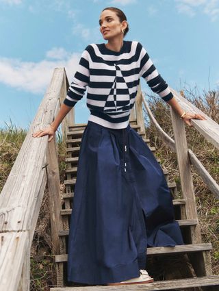 model wearing striped sailboat sweater and navy maxi skirt from White + Warren