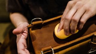 Buffing a brown leather handbag