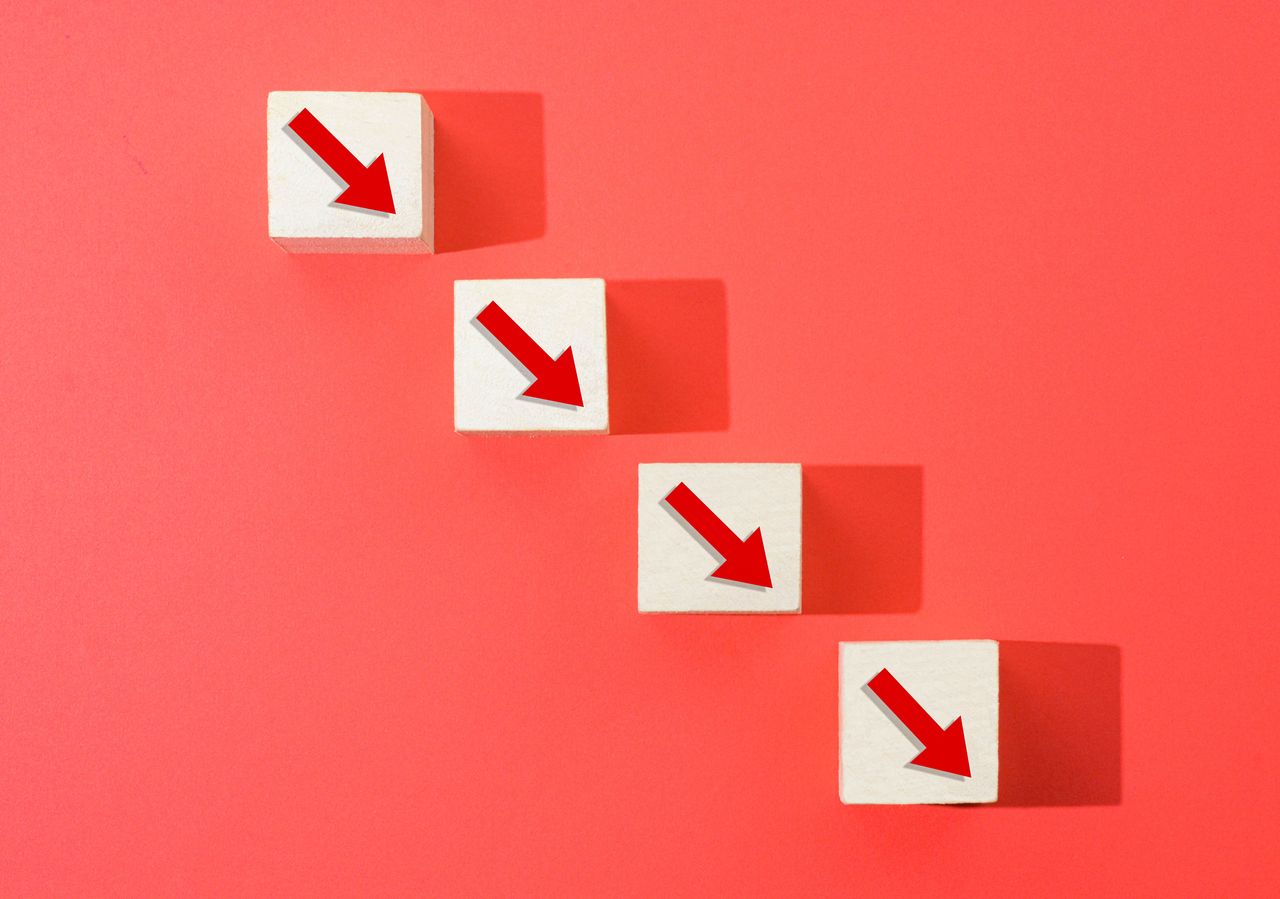 four wooden blocks with red arrows in a diagonal line and red backdrop