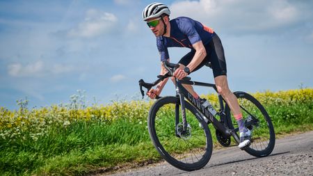 cyclists descending, and leaning into a corner, showing off some of the best road bike wheels 