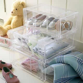 clear plastic shoe boxes with shoes and blankets