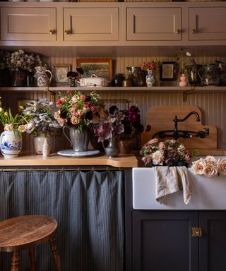 traditional style pink kitchen with a grey pinstriped cabinet curtain