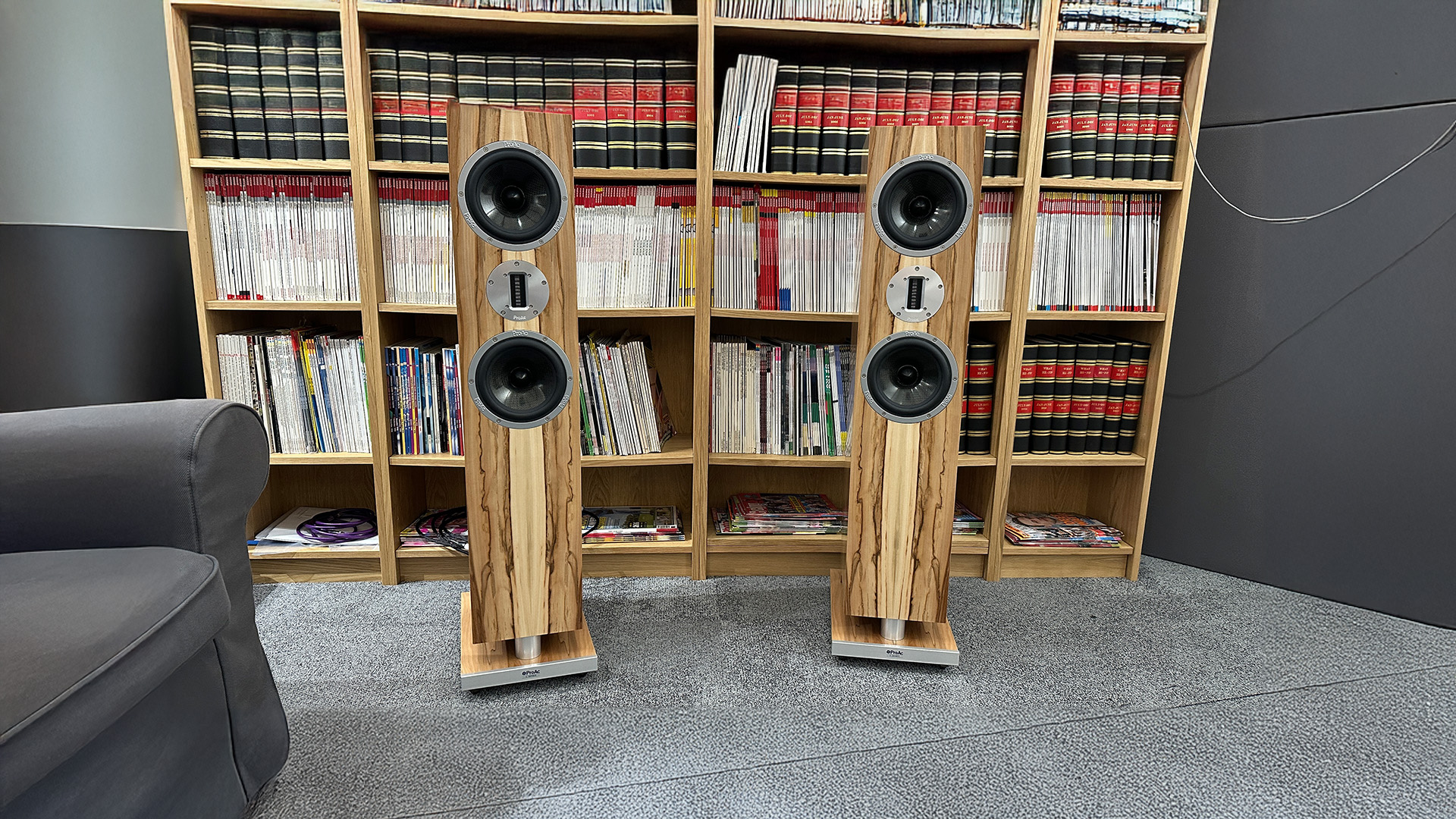 ProAc K3 floorstanding speakers on grey carpet in front of bookcase