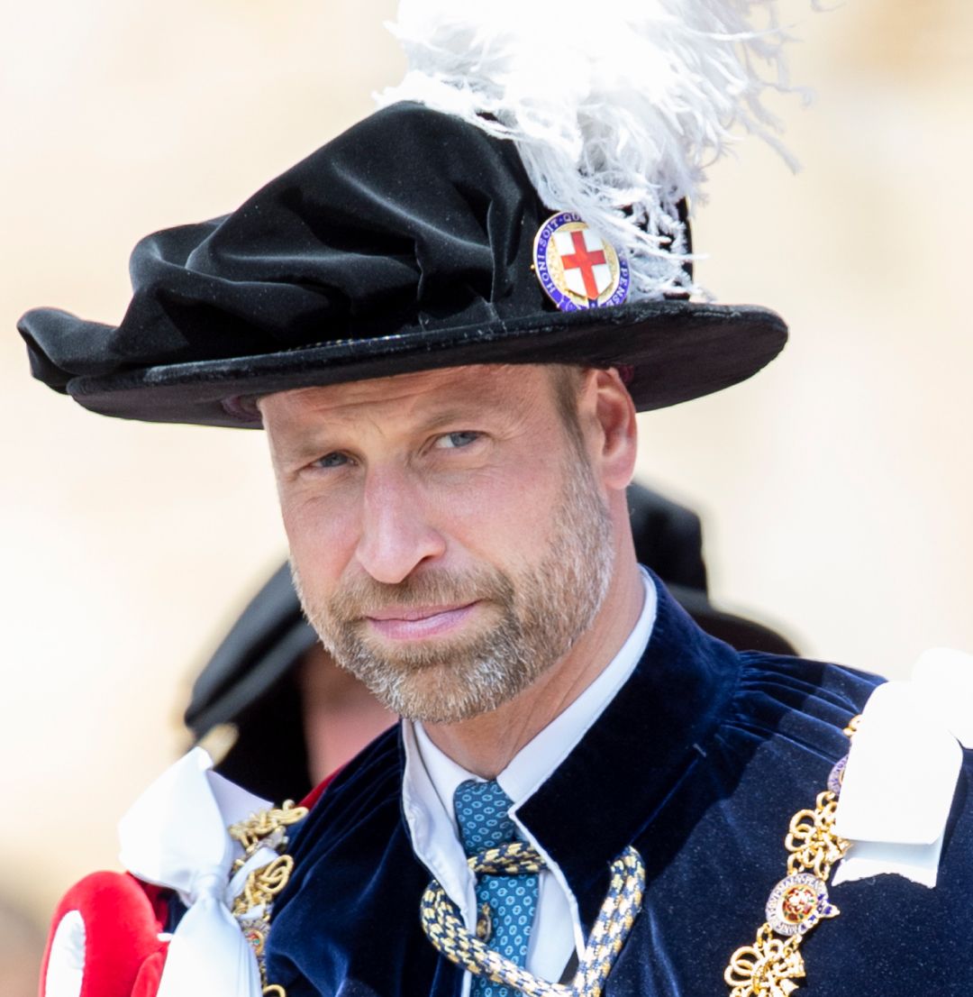 Prince William wearing a plumed hat and a cape 