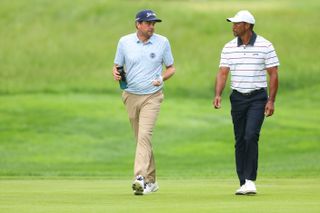 Keegan Bradley and Tiger Woods walk down the fairway at the PGA Championship