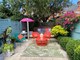 An outdoor rug on deck with red bistro set