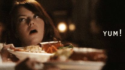 Girl pulls a face at a plate of food.