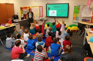 Students participate in classroom lesson with BenQ flat panel display.
