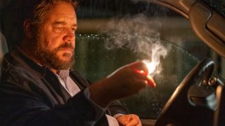 Russell Crowe stares menacingly at a lit match in Unhinged.
