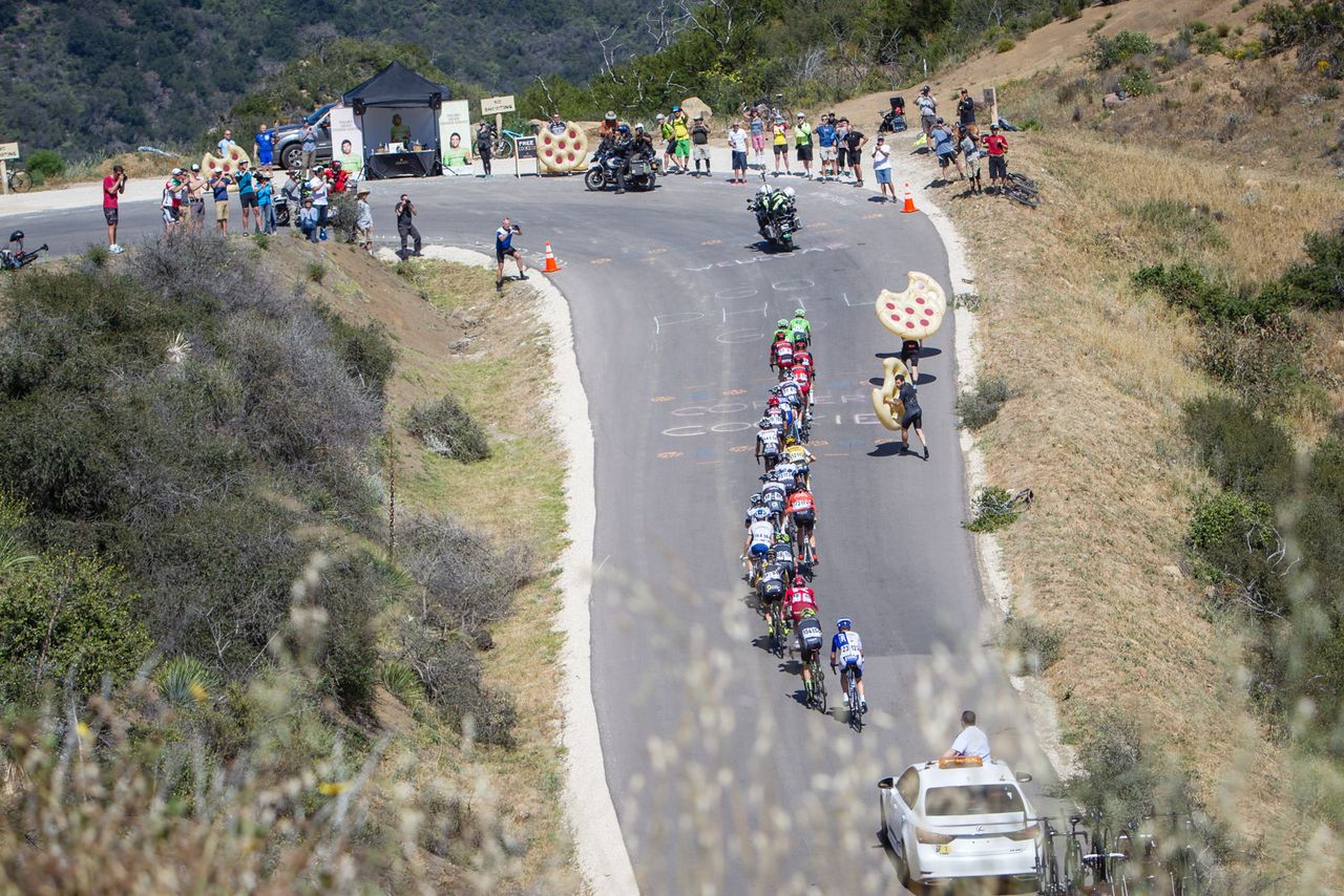 Fans hold large cookies to cheer the peloton on