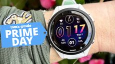 Garmin Forerunner 265 on a wrist with pink flowers out of focus behind