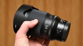 Nikon Z 35mm f/1.2 S product shot with lens held in hand